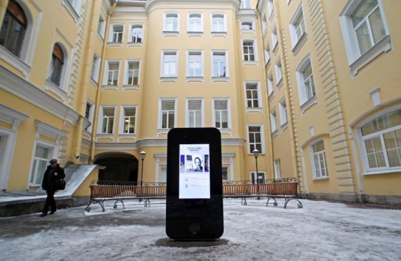 A man walks past a recently erected iPhone-shaped monument in memory of Apple's late co-founder Jobs in St. Petersburg